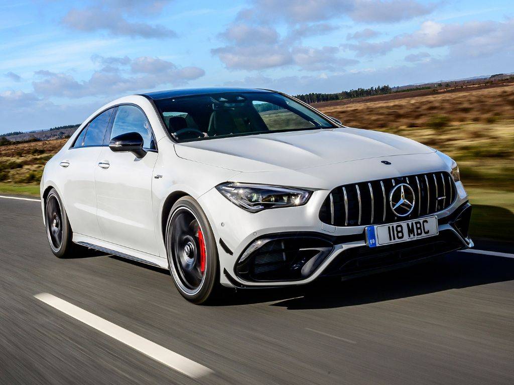 Na obrázku je zobrazený Mercedes-Benz CLA 45S AMG, športový sedan, ktorý kombinuje štýl, výkon a inovatívne technológie. Vozidlo má dynamický a aerodynamický dizajn s výraznými líniami a agresívnym vzhľadom, ktorý podčiarkuje jeho športový charakter. Predná časť je vybavená veľkou mriežkou chladiča AMG a štíhlymi LED svetlami, ktoré dodávajú autu moderný a futuristický vzhľad. Vozidlo je v elegantnom metalickom odtieni a vyzerá pôsobivo vďaka nízkemu, širokému profilu. Veľké kolesá a športové detaily na karosérii, ako sú difúzory a výfuky, naznačujú, že je to vozidlo určené pre nadšencov výkonu. Interiér kombinuje luxus s technologickými prvkami, s moderným infotainment systémom a vysokokvalitnými materiálmi. Mercedes-Benz CLA 45S AMG je poháňaný silným motorom, ktorý zabezpečuje rýchlu a vzrušujúcu jazdu, ideálny pre tých, ktorí hľadajú výnimočnú kombináciu luxusu a športového výkonu.